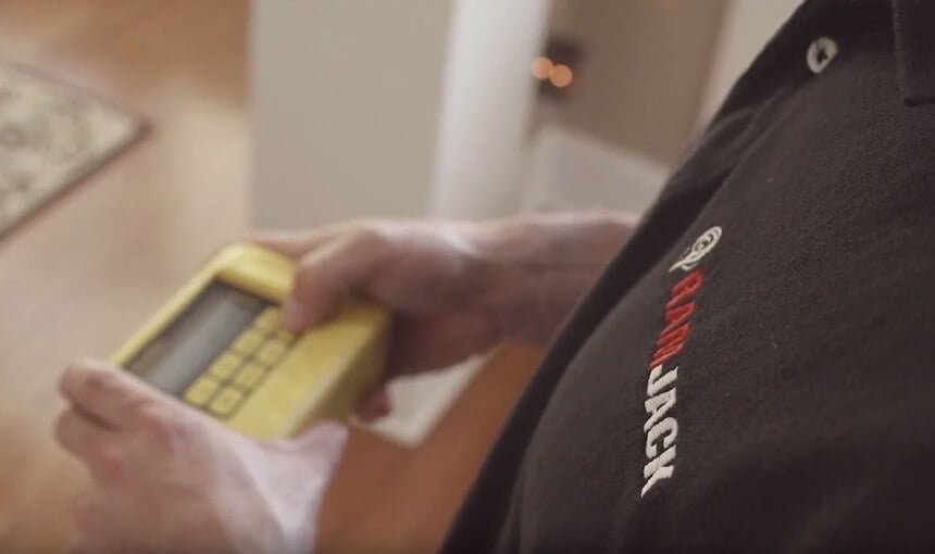 a ram jack expert is taking elevation readings in a home trying to assess if there is foundation damage