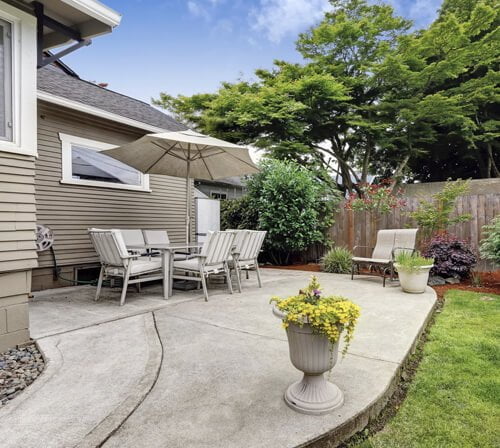 a concrete patio in a nice backyard